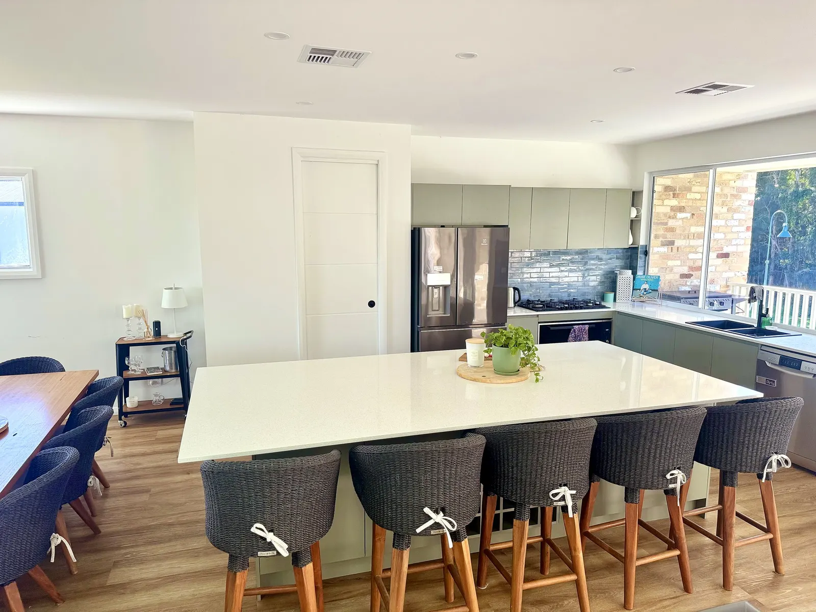 Open-plan living room at Drift, Tea Gardens — lounge, kitchen and deck beyond