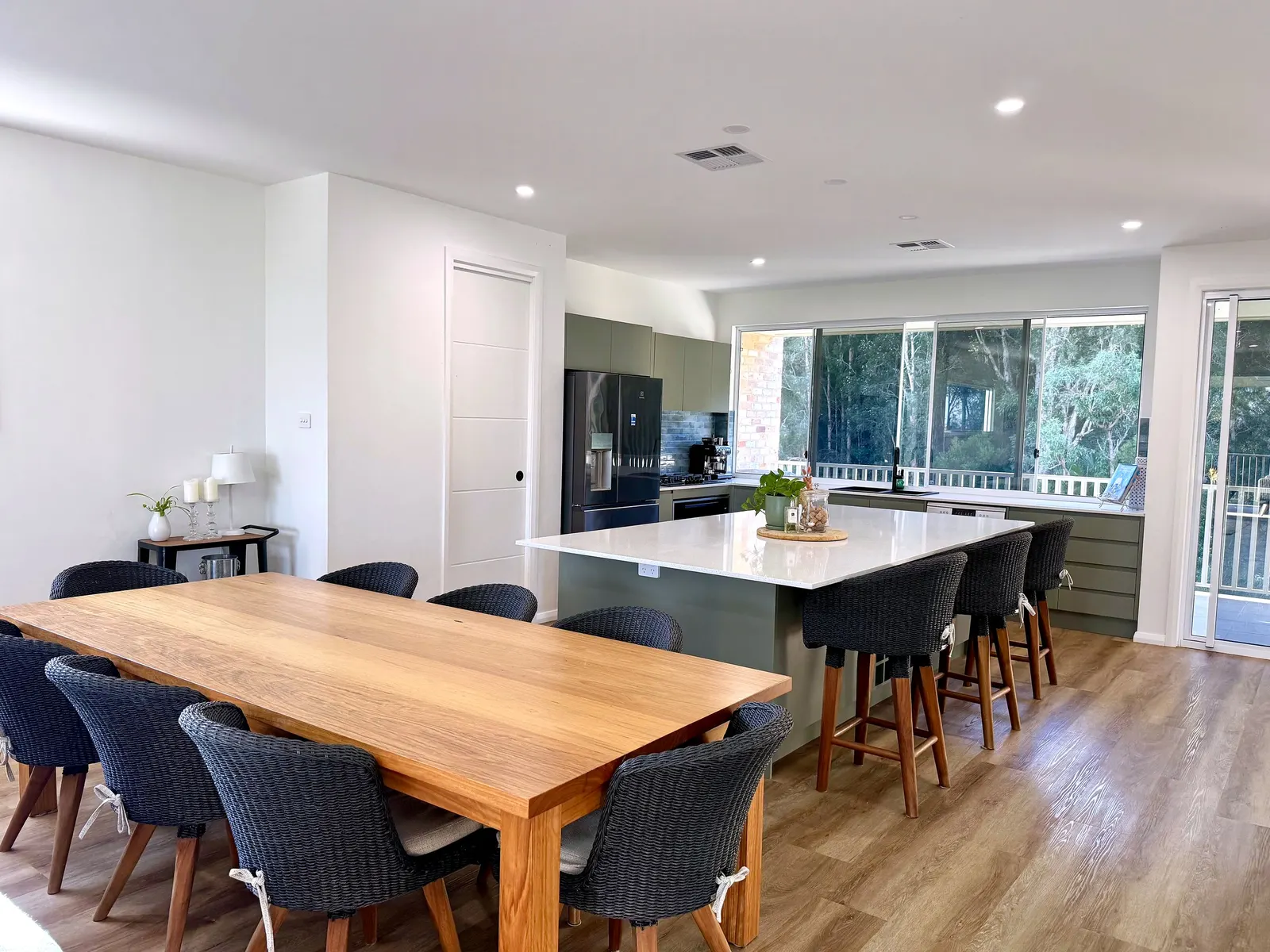 Kitchen with sage cabinetry, stone benchtop and bush outlook