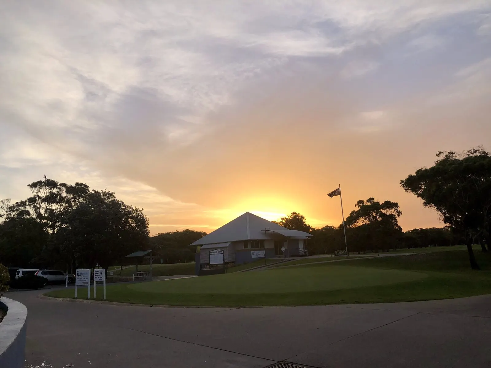 Sunset over the clubhouse and putting green at Hawks Nest Golf Club