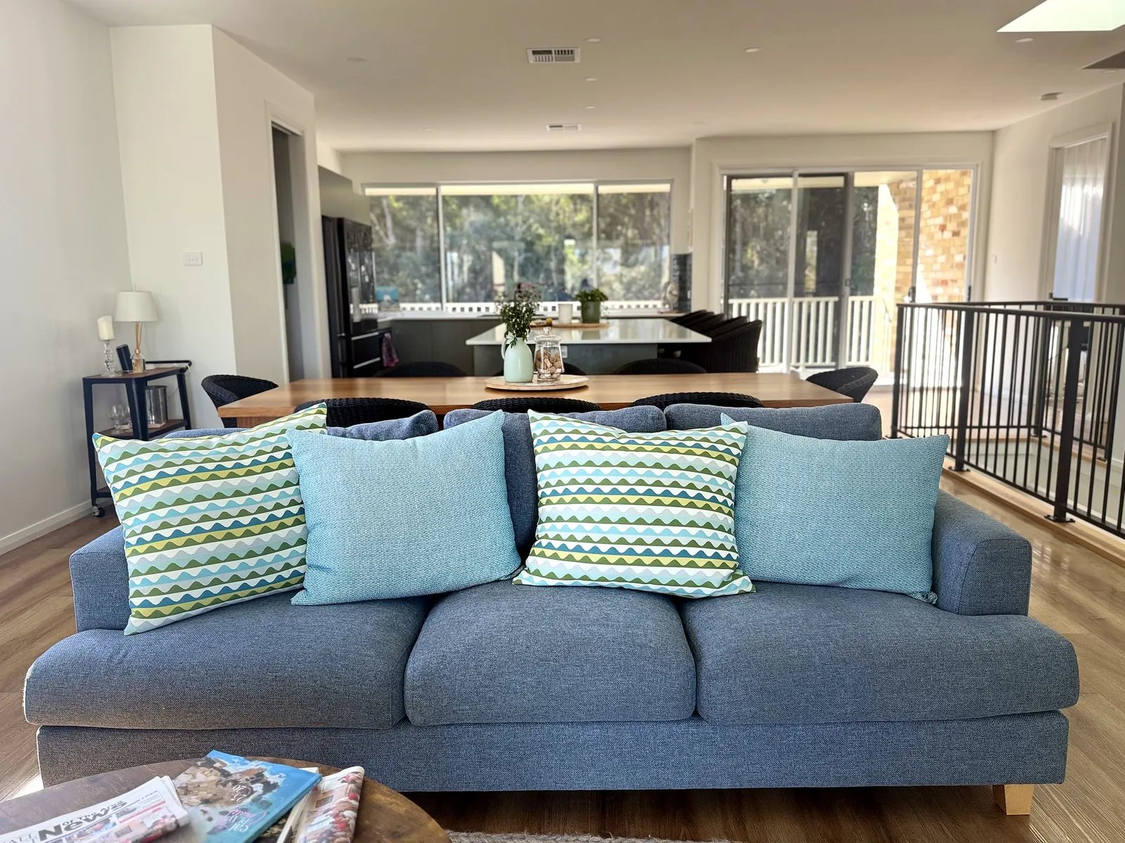 Timber dining table and lounge area at Drift, Tea Gardens