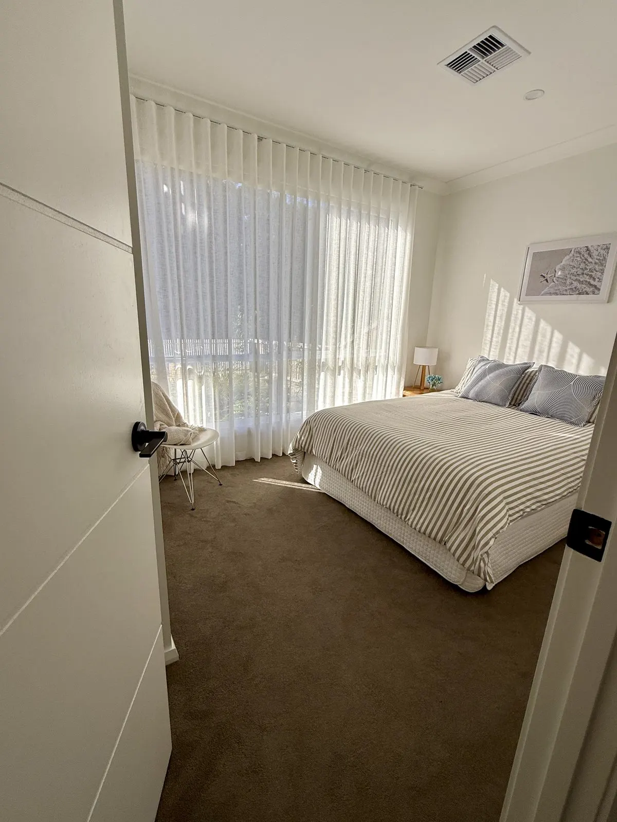 Queen bedroom with sheer curtains and balcony outlook at Drift