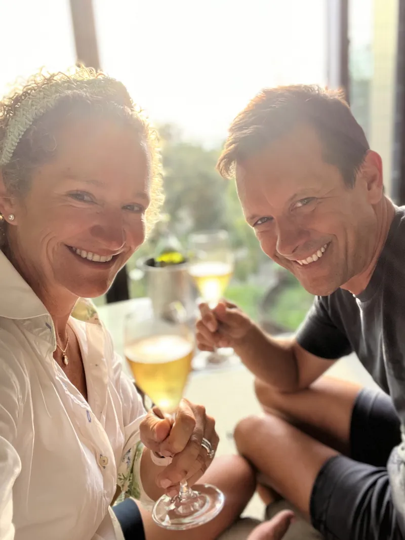 Matt and Mandy smiling and raising a glass together